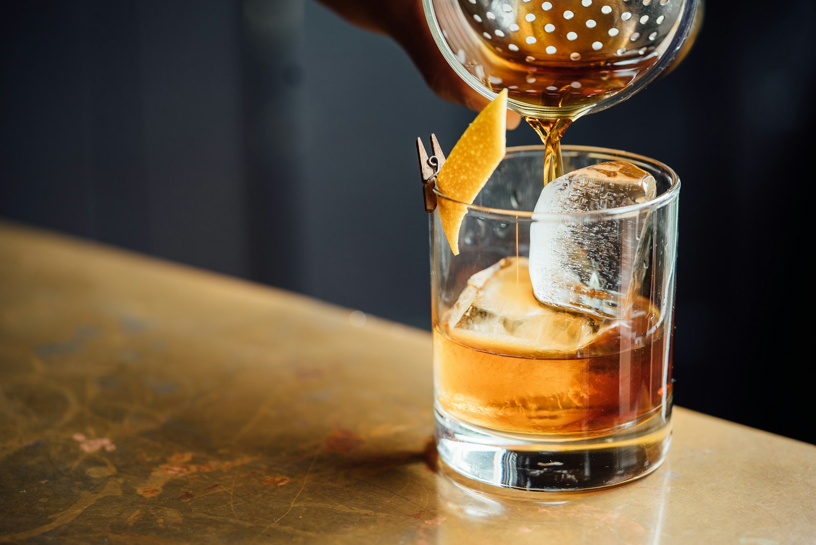 A row of classic cocktails lit against a dark bar